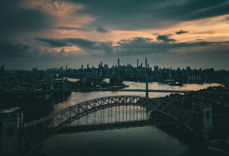 a bridge over a river with a city in the background by Venti Views courtesy of Unsplash.