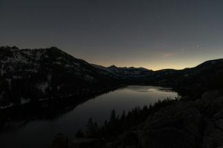 mountain and tree reflecting on body of water by Levi Bare courtesy of Unsplash.